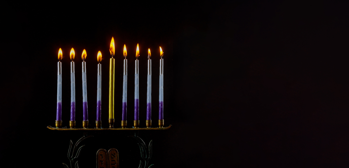 Hanukkah Menorah with all eight candles lit in dark room