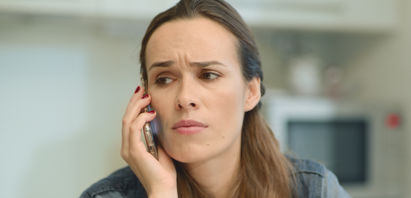 Woman on phone in thought. 5 Things People Often Forget When Planning a Funeral